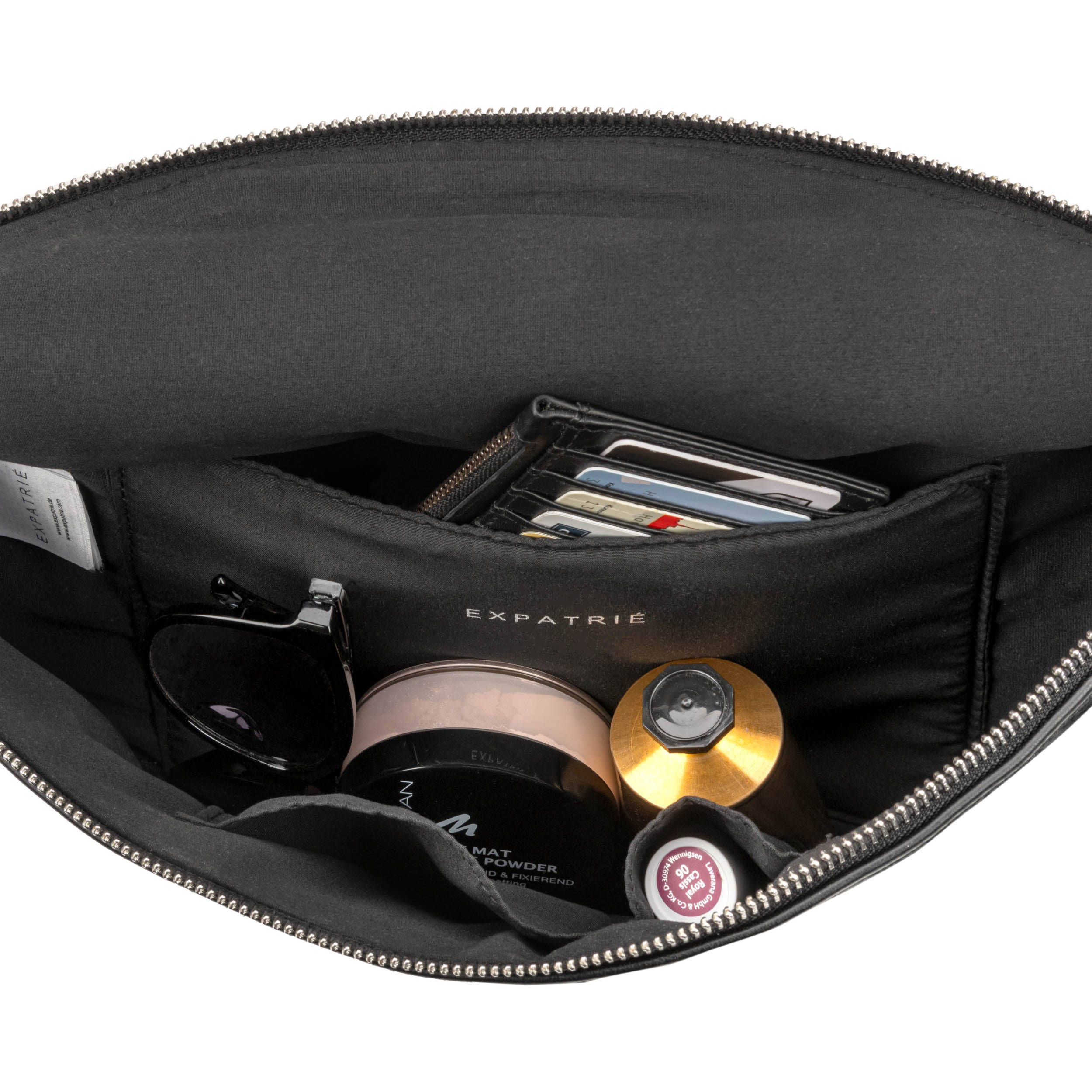 Innenansicht der schwarzen Bauchtasche Alice Large mit mehreren Fächern, gefüllt mit Sonnenbrille, Kosmetikprodukten und Kartenetui