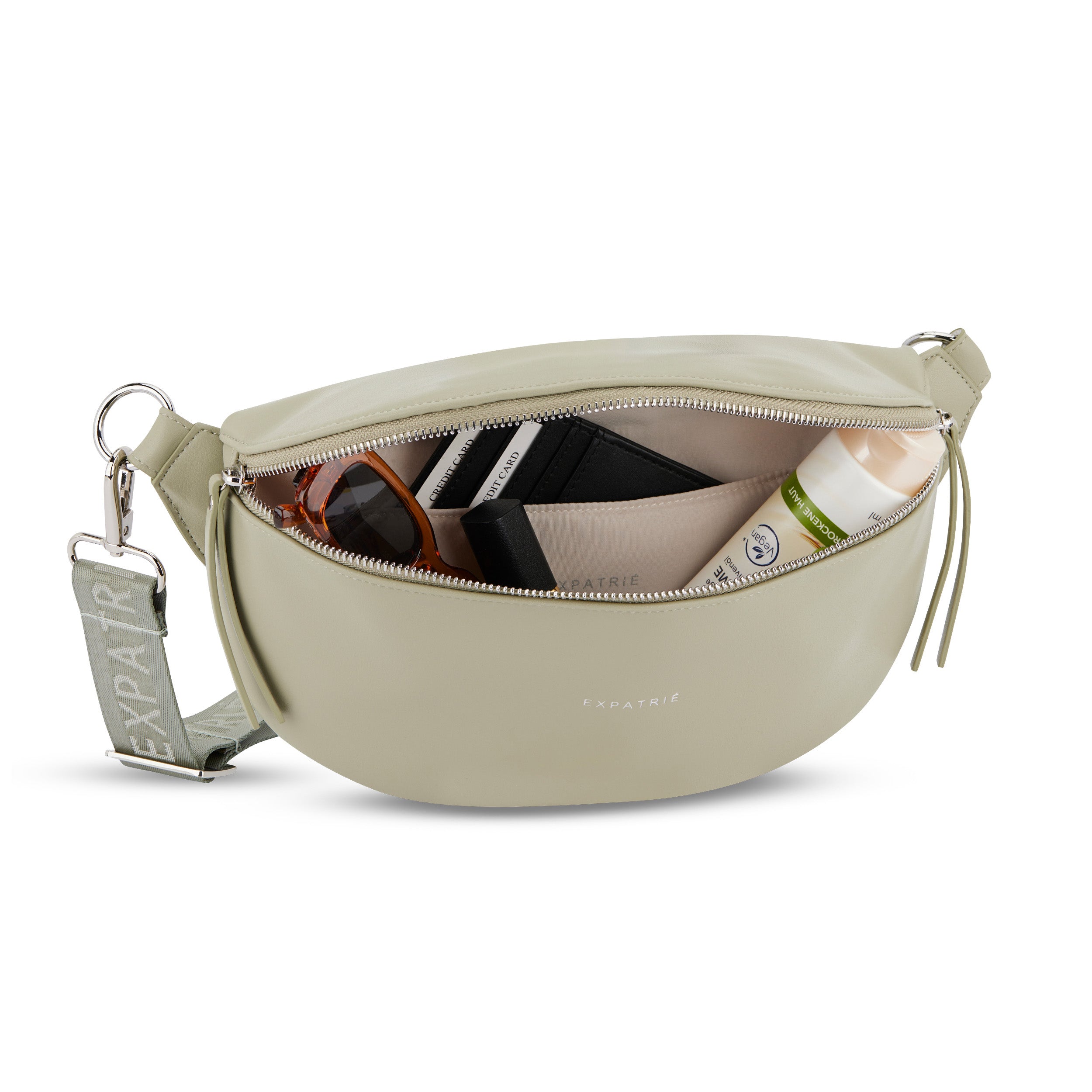 Expatrié Bauchtasche Alice Medium in beige mit Reißverschluss, gefüllt mit Sonnenbrille, Kartenetui und Hautpflege
