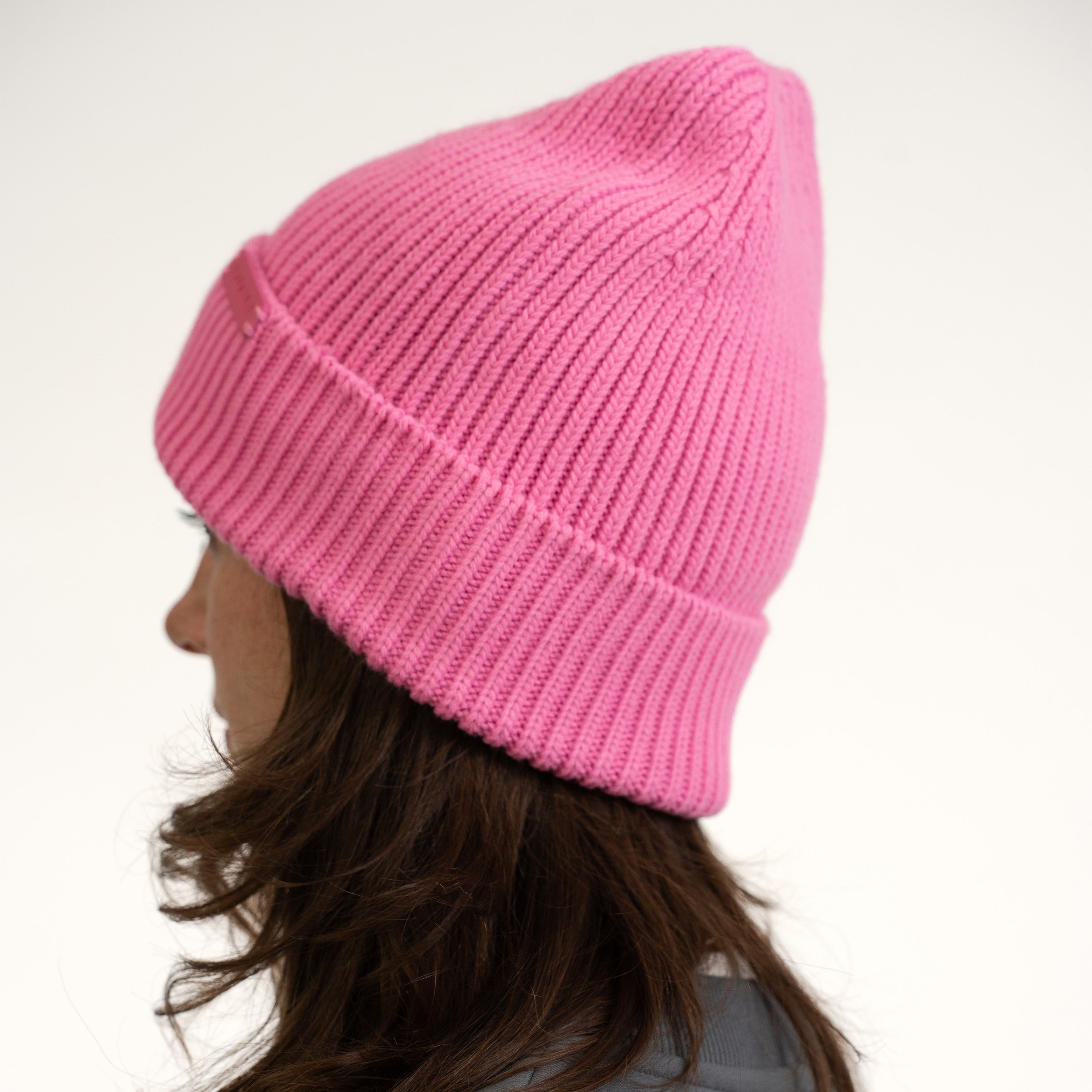 Rosa gestrickte Damen-Mütze Luna mit Umschlag, getragen von Frau mit braunen Haaren
