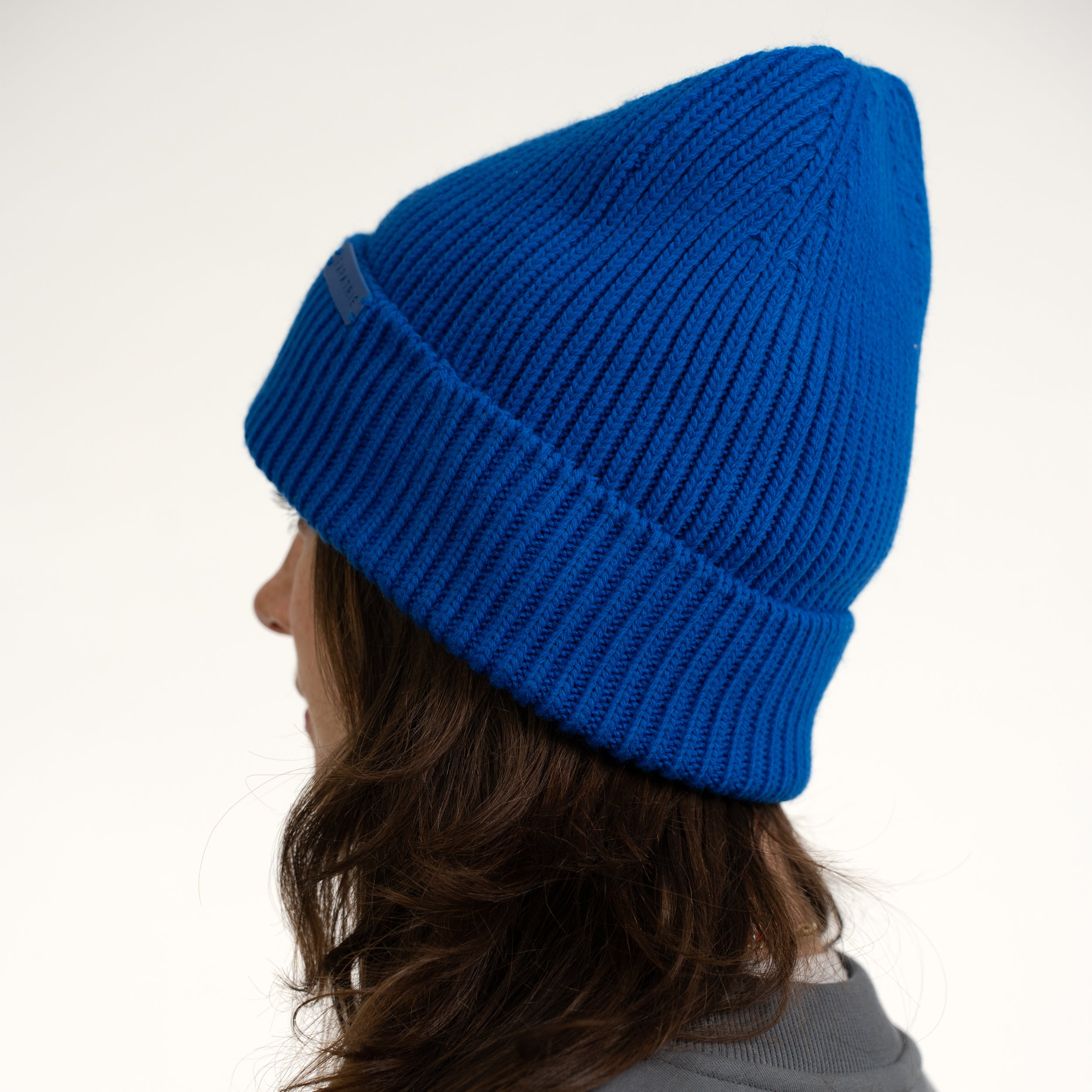 Strickmütze Luna in Royalblau auf dem Kopf einer Frau von hinten