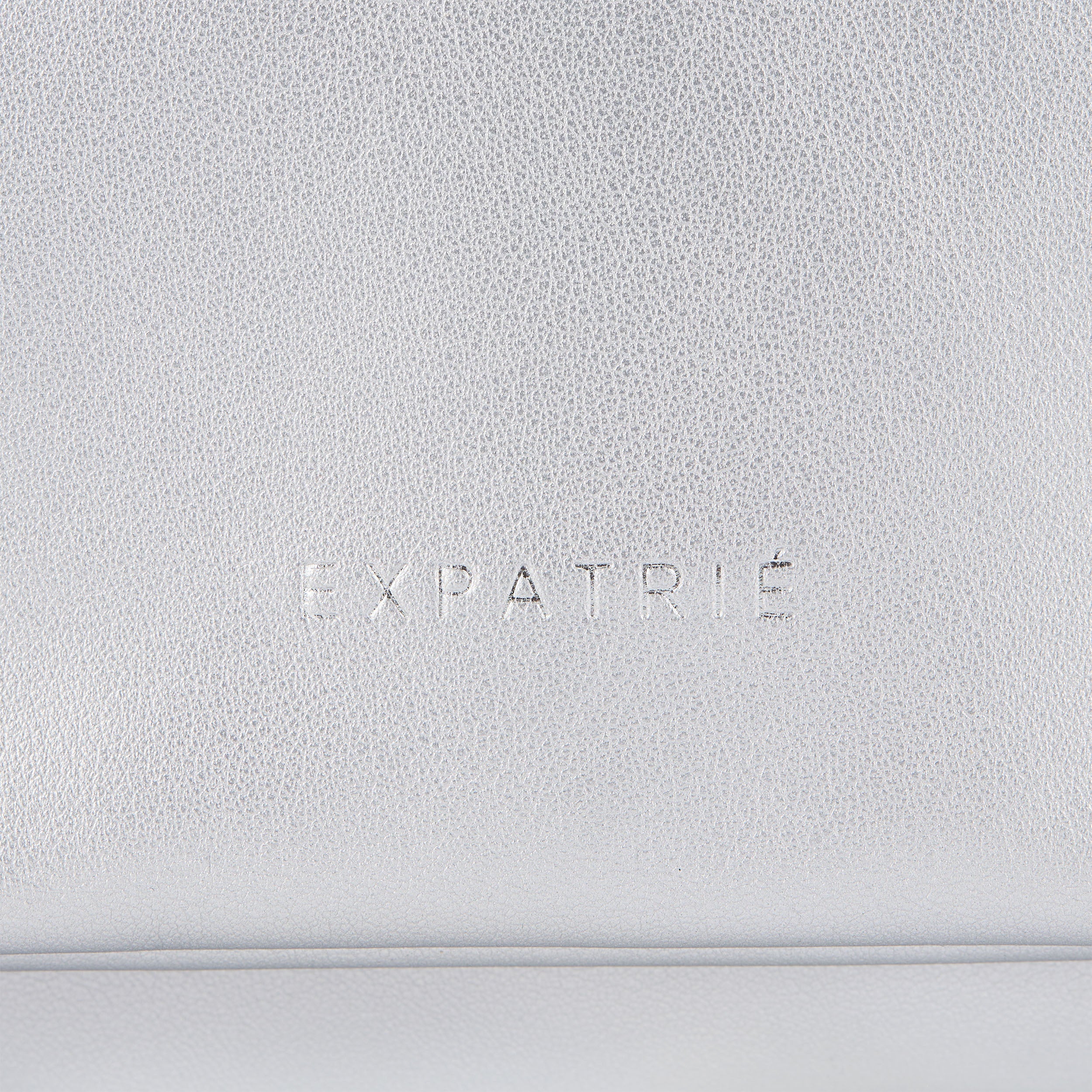Silbersilberne Clutch Handtasche namens Juliette von Expatrié aus strukturiertem Material mit Logo-Prägung