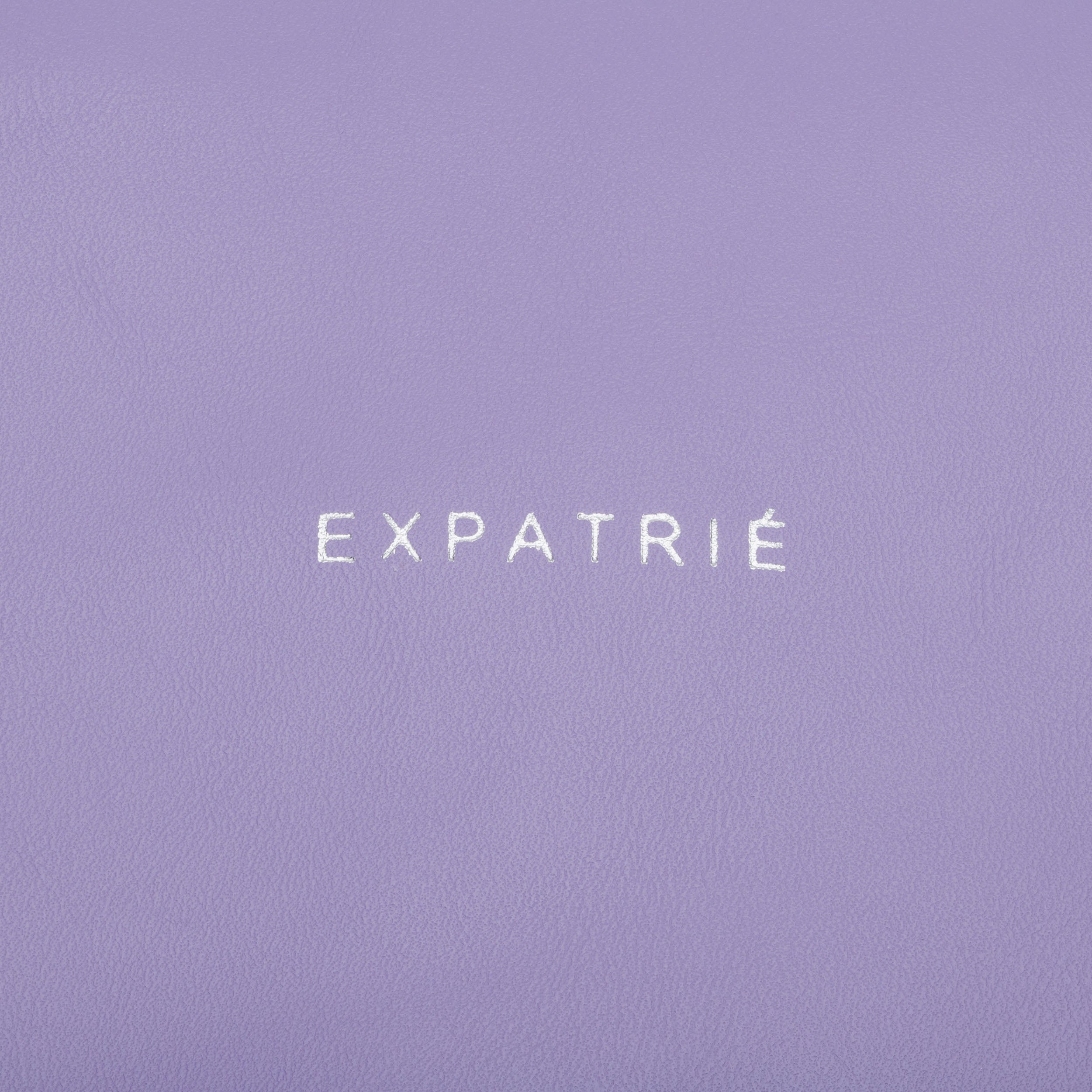 Lila Kunstleder mit weißem 'EXPATRIÉ'-Logo auf Clutch Emilie
