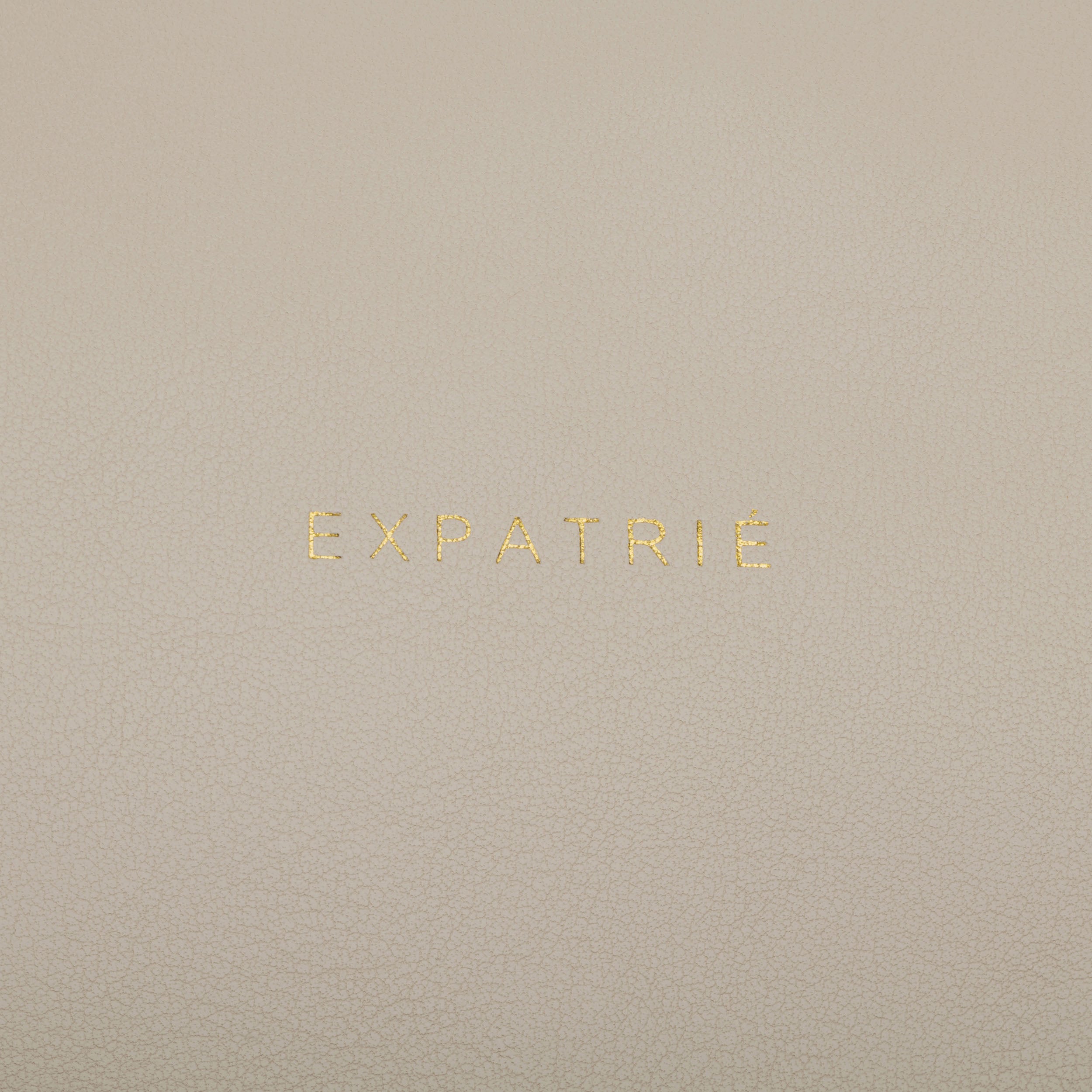 Beige-braune Lederclutch mit goldener Prägung 'EXPATRIÉ'