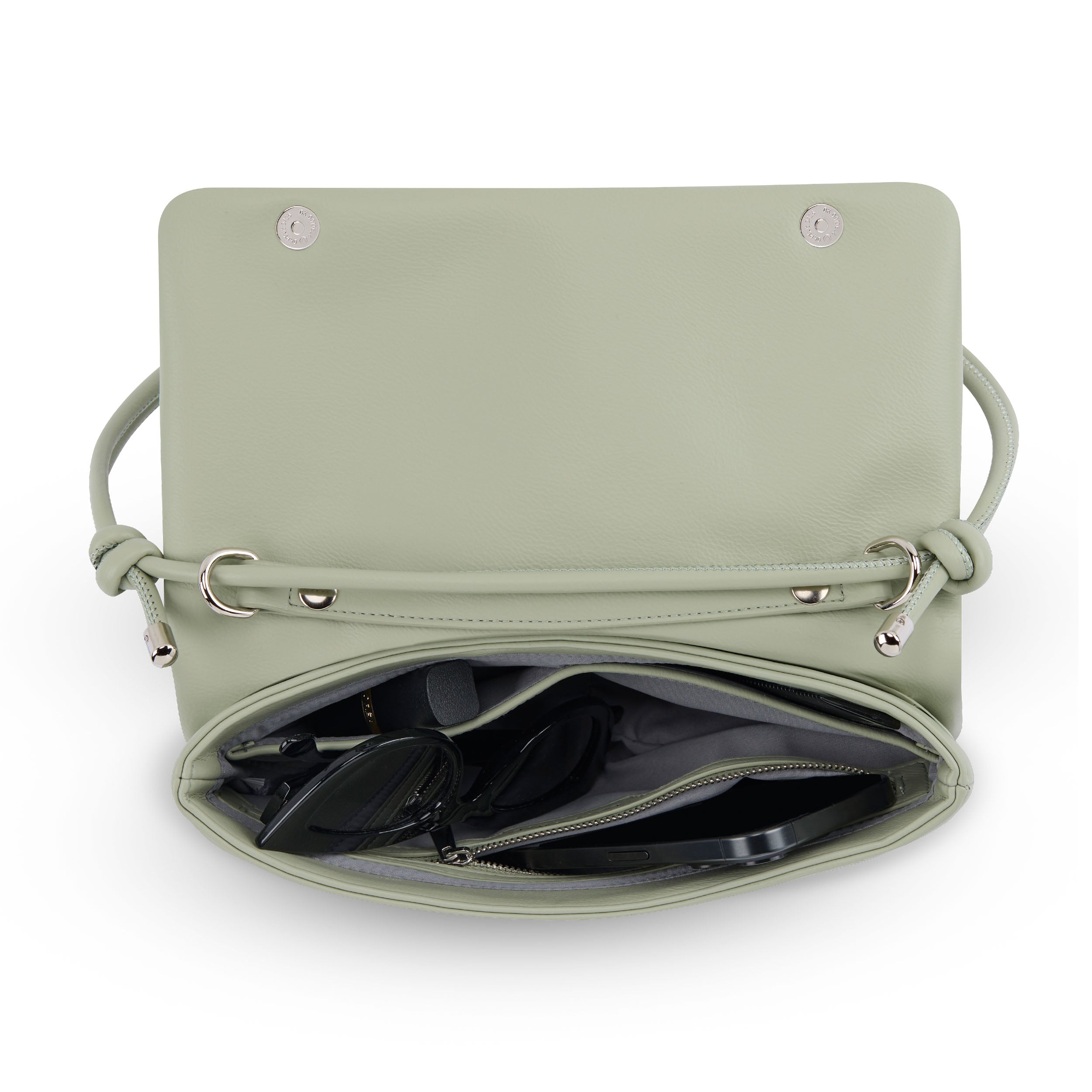 Grüne Clutch 'Juliette' aus Leder mit geöffnetem Klappverschluss, Innenfach mit Brille und Smartphone