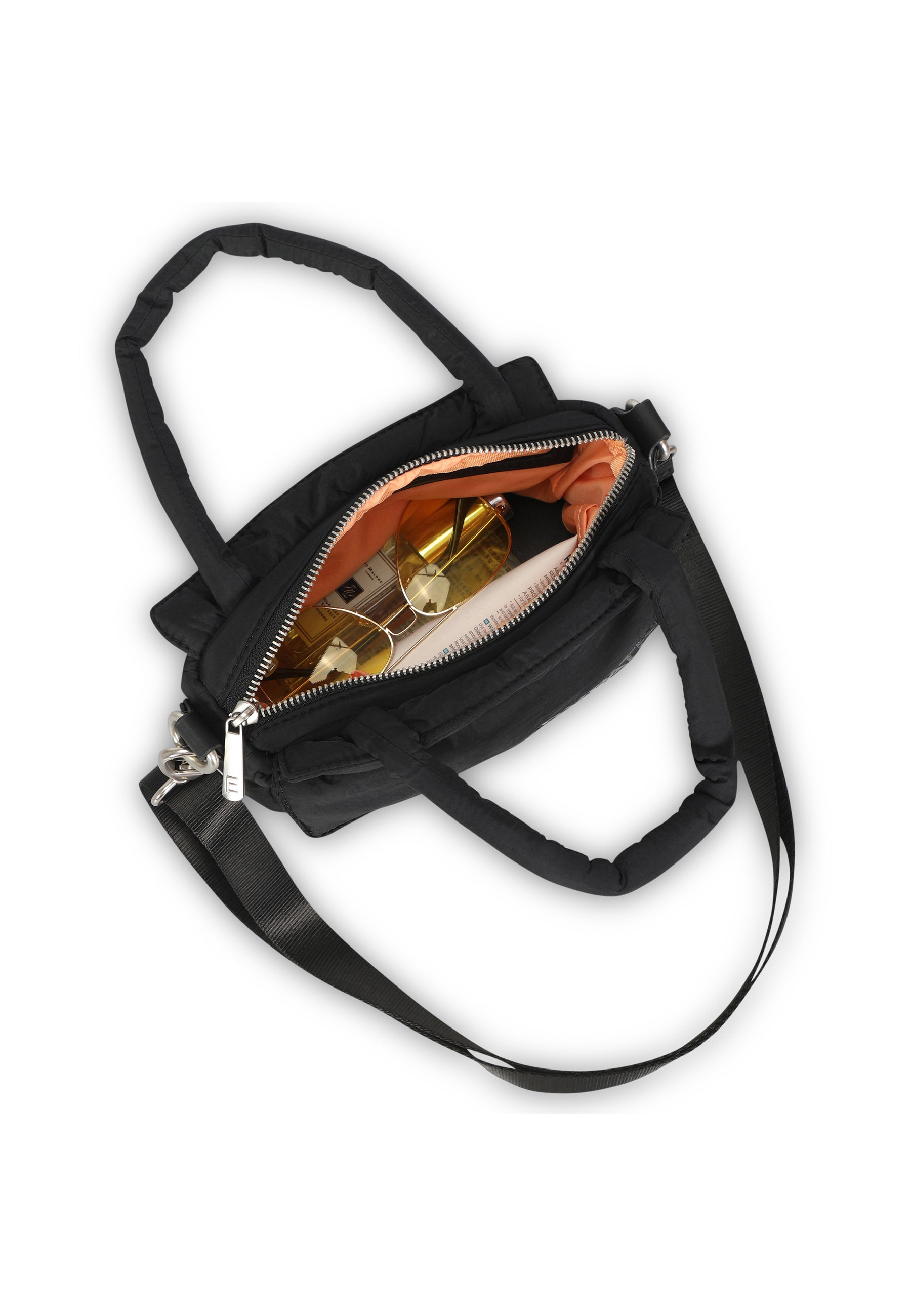 Schwarze Handtasche 'Poppy Small' mit Reißverschluss geöffnet, darin Sonnenbrille mit goldenen Gläsern und andere Gegenstände
