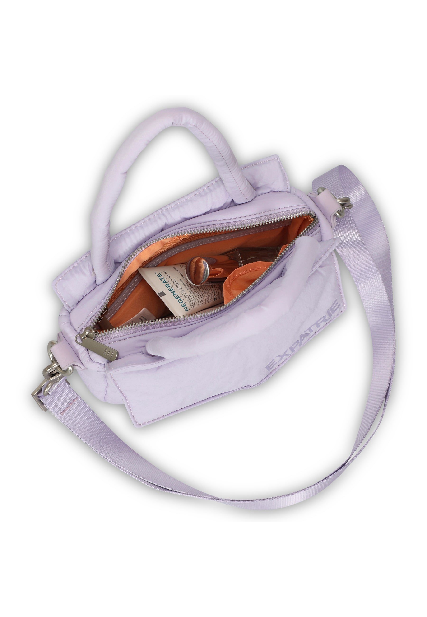 Violette kleine Handtasche 'Poppy Small' mit Reißverschluss geöffnet, orangefarbenes Innenfutter und Kosmetikartikeln innen