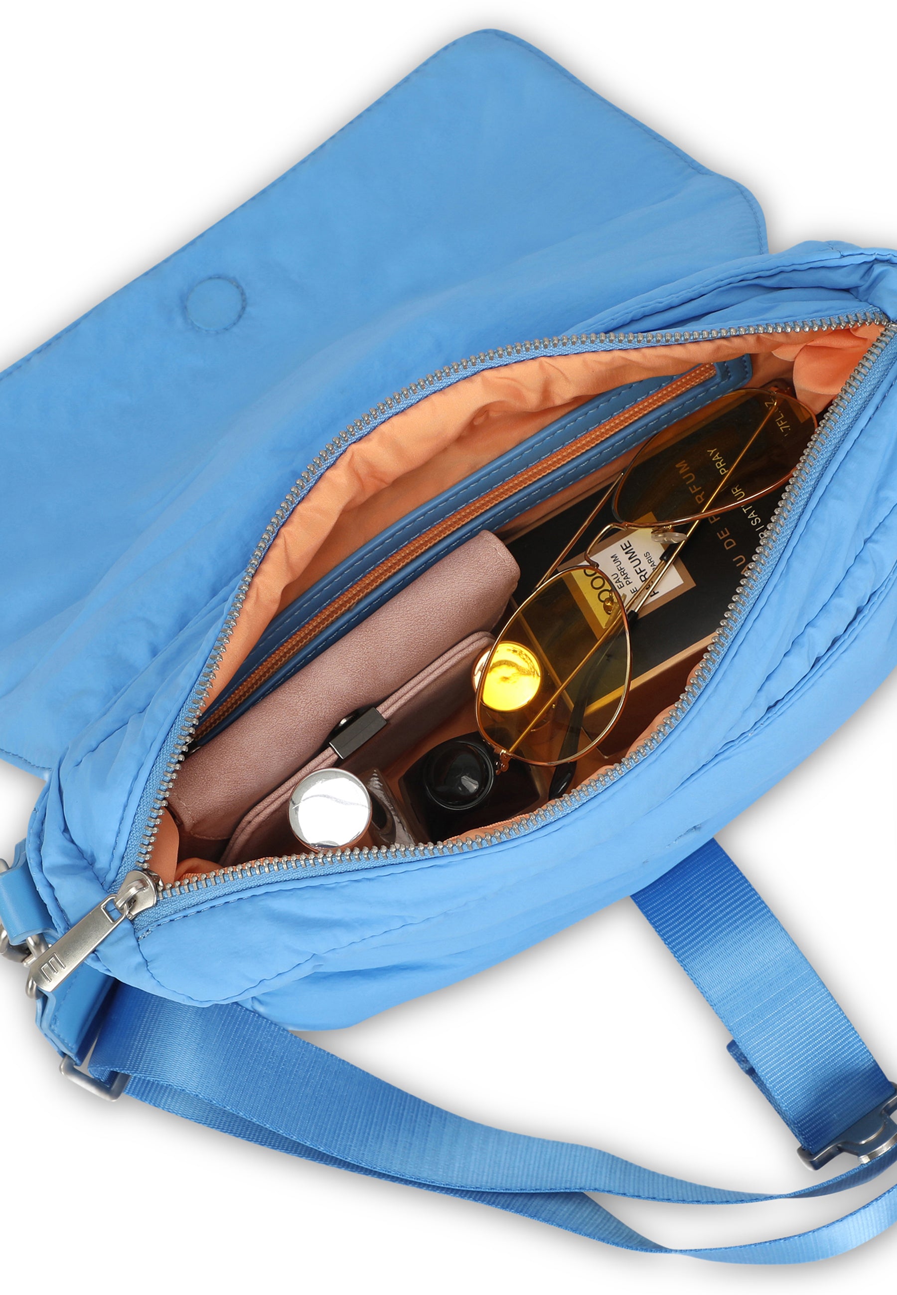 Bobby Handtasche in Royalblau mit offenem Reißverschluss, befüllt mit Sonnenbrille, Parfüm, Portemonnaie und Lippenstift