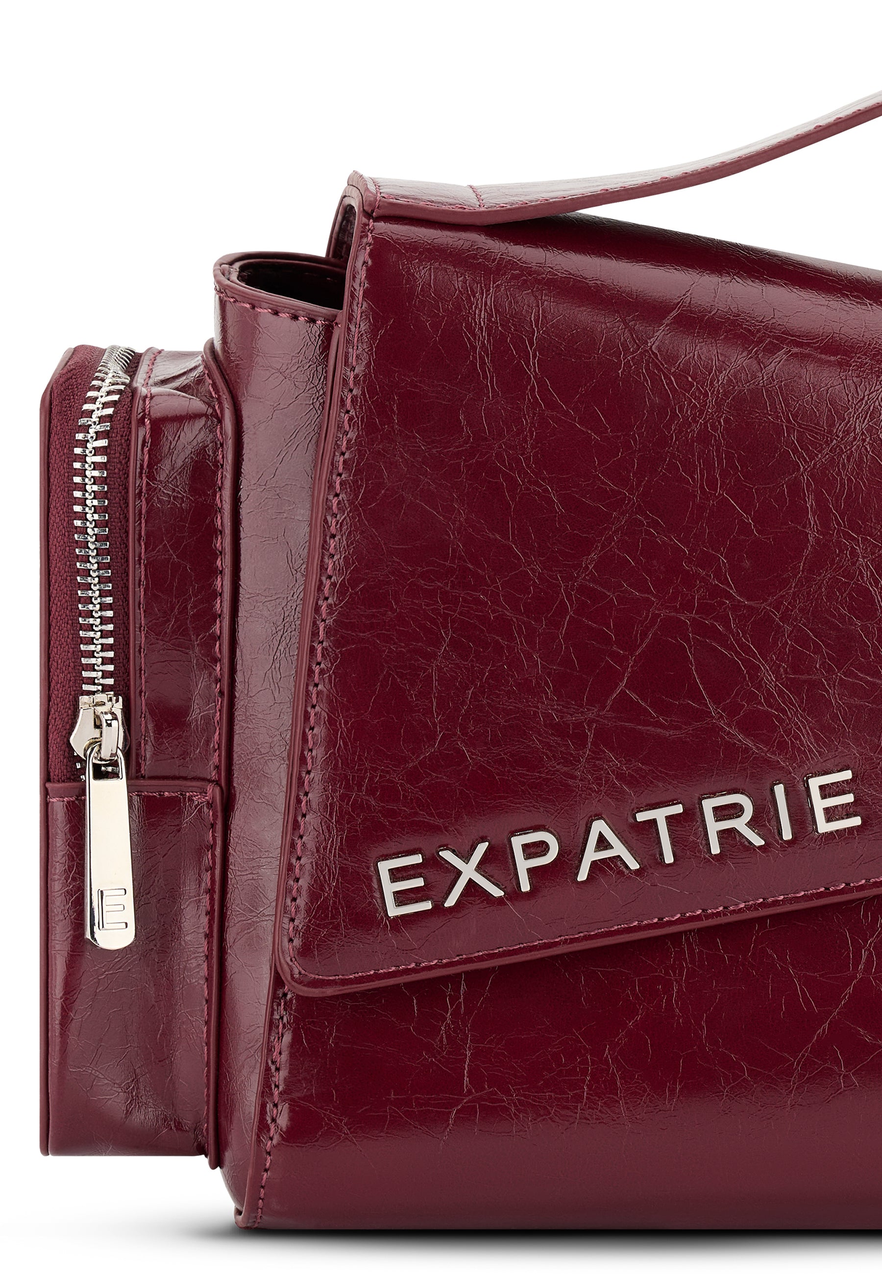 Weinrote HUNTER Handtasche aus glänzendem Material mit silbernem Reißverschluss und 'EXPATRIE' Schriftzug