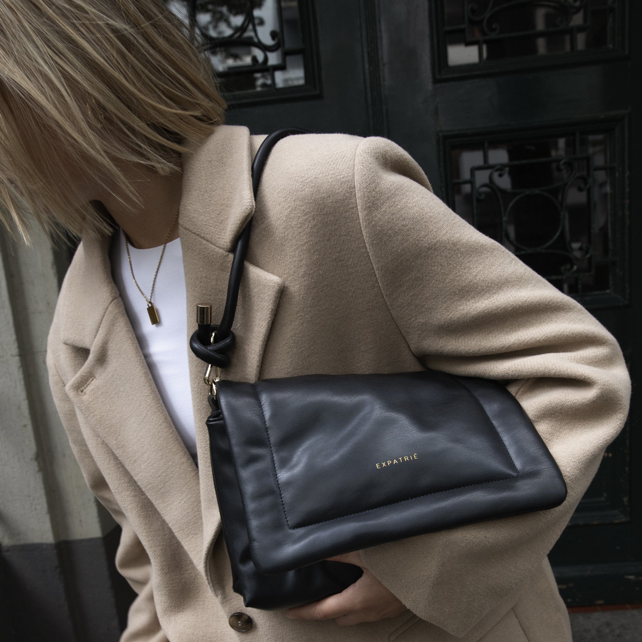 Frau mit beige Mantel trägt schwarze Umhängetasche Zoe Medium von Expatrié