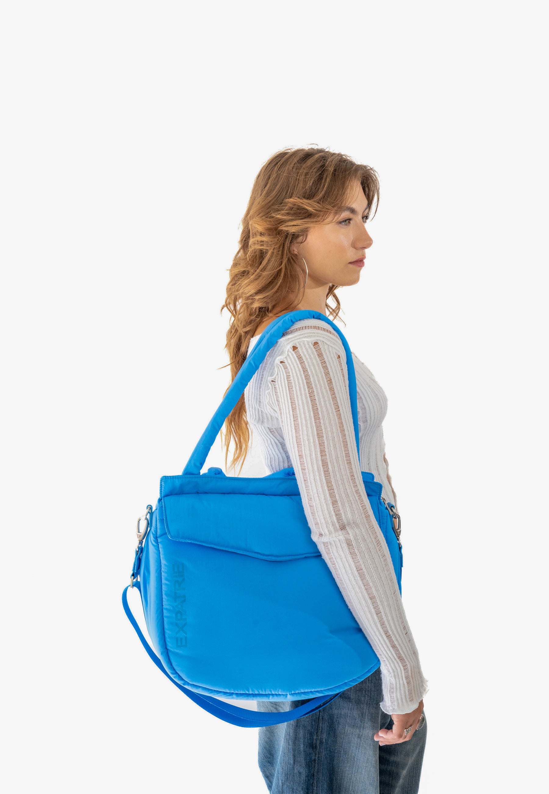 Frau von der Seite mit royalblauer POPPY Shopper Tasche aus Stoff und verstellbarem Schulterriemen