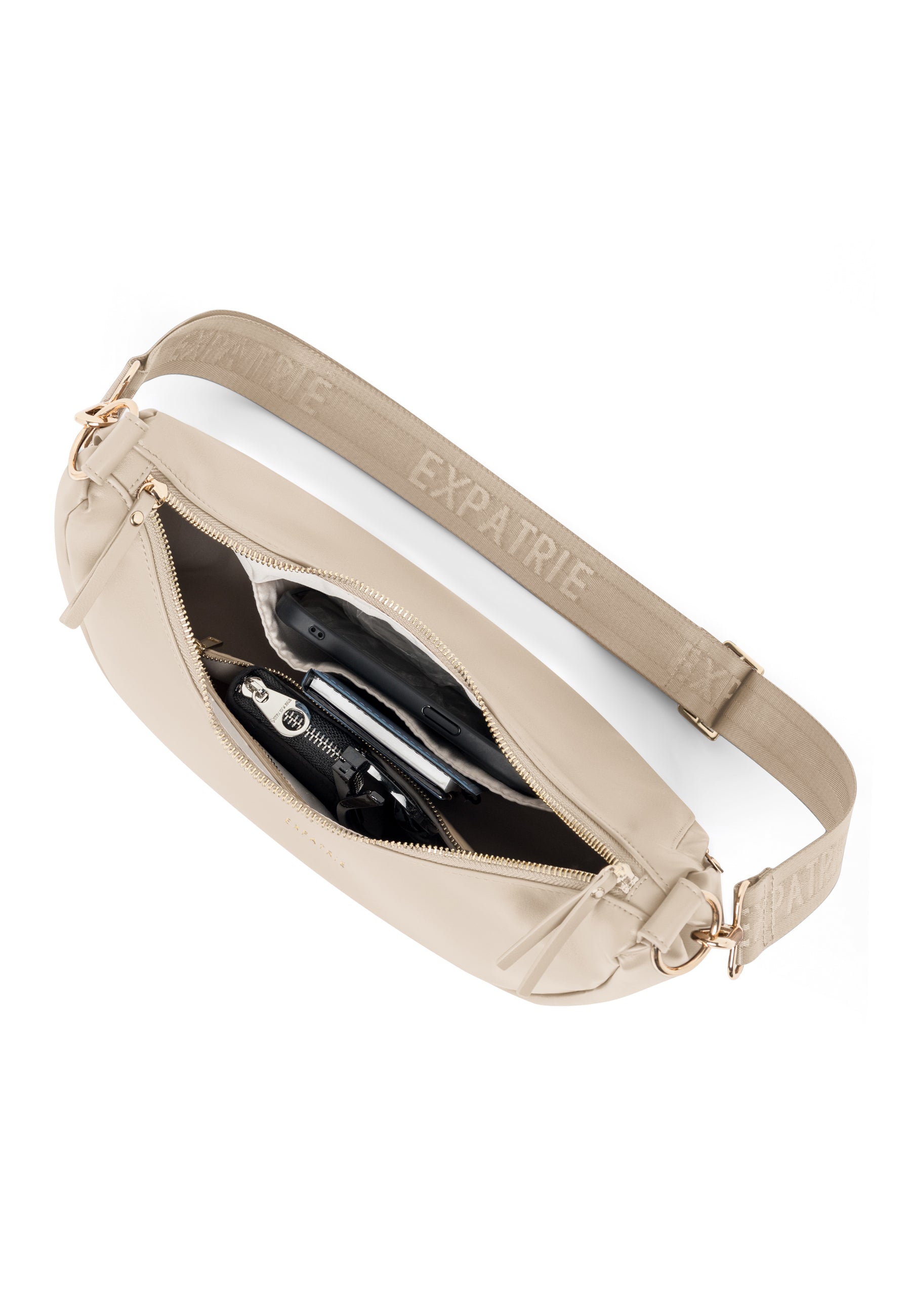 Beige LEA MEDIUM Half Moon Tasche mit Reißverschluss offen, Innenfach mit mehreren Gegenständen, verstellbarer Schulterriemen mit Expatrié-Schriftzug