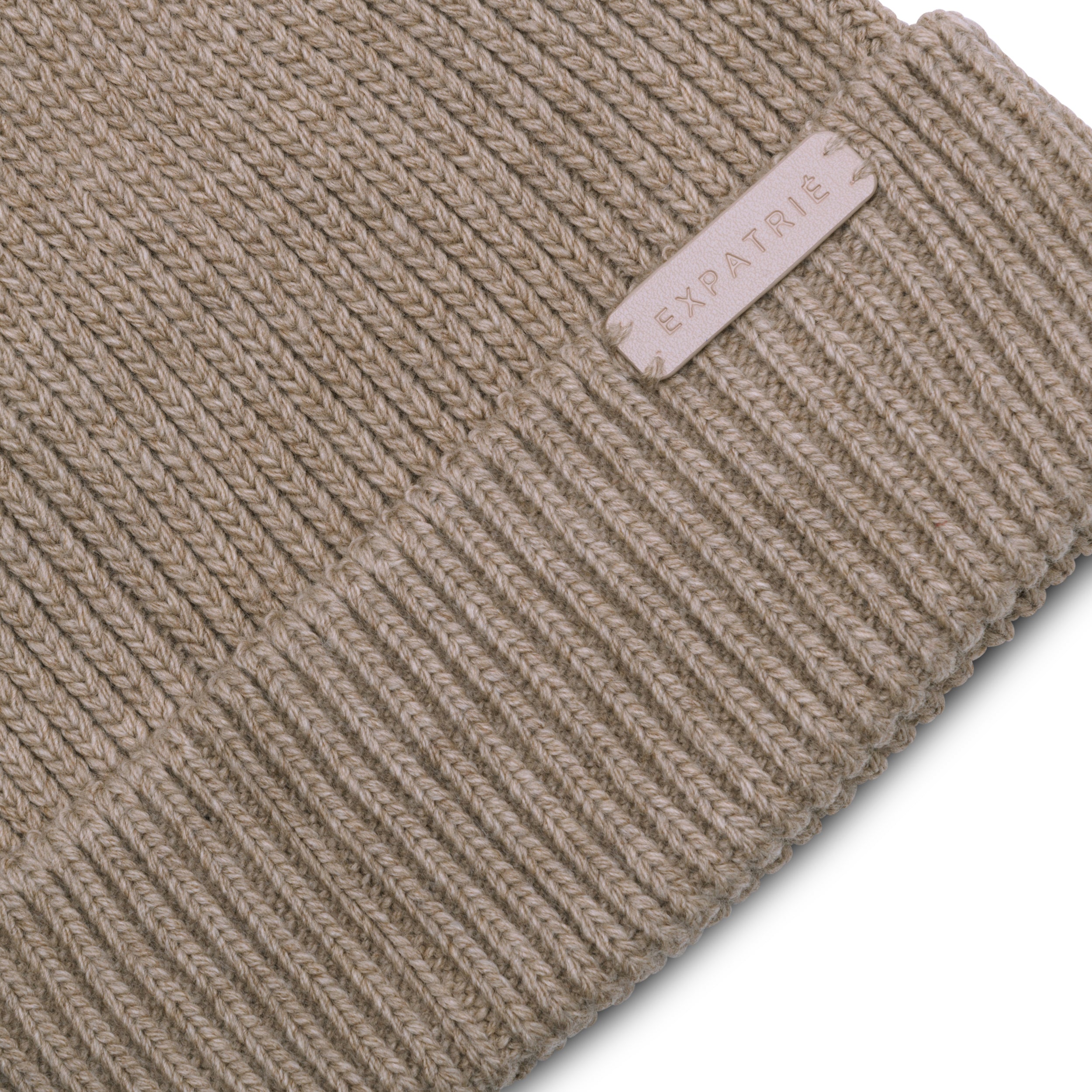 Beige gestrickte Mütze Luna mit Expatrié Logo auf einem kleinen Schild