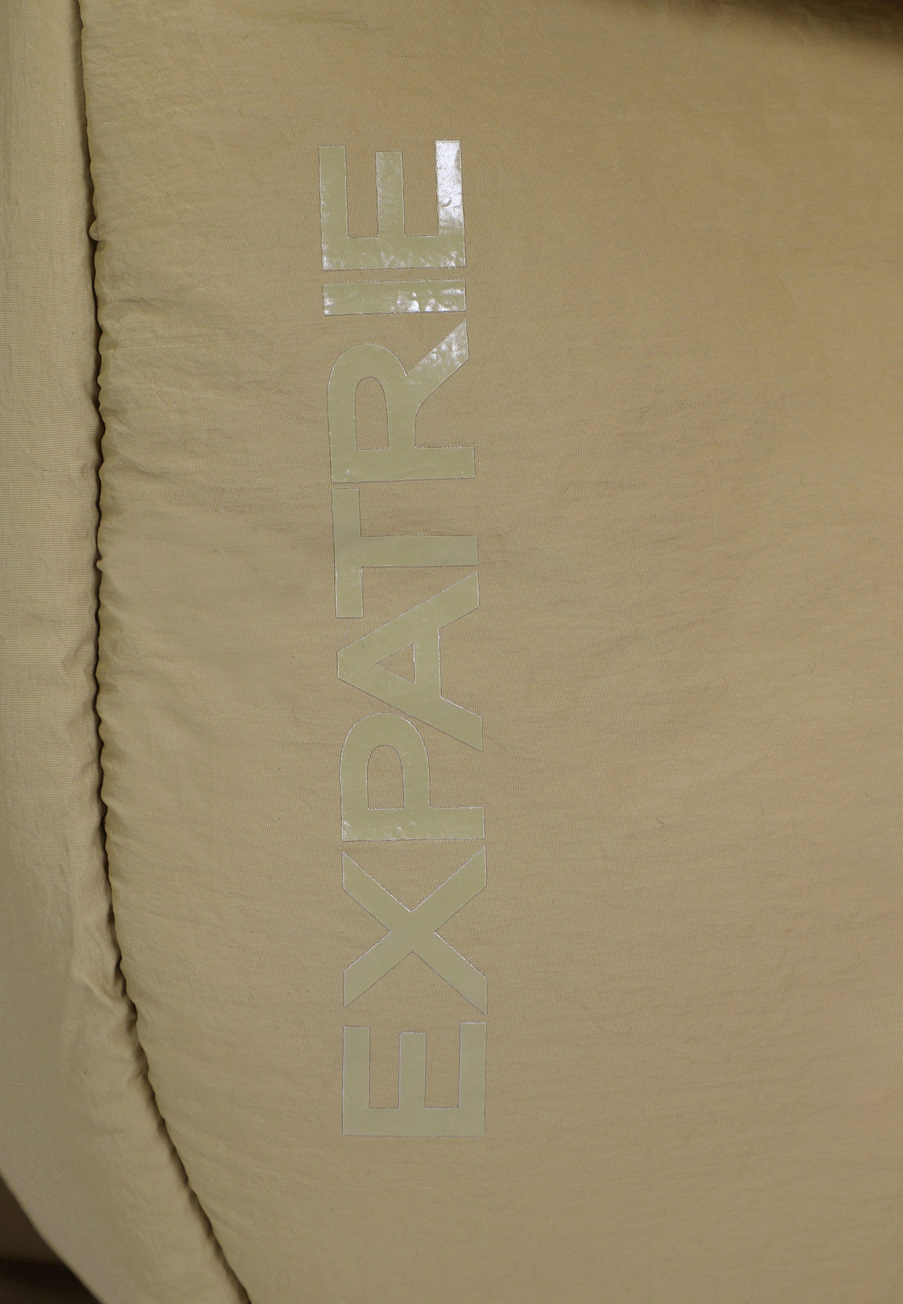 Nahe Aufnahme der beige Puffer-Shopper Tasche mit glänzendem 'EXPATRIE' Logo