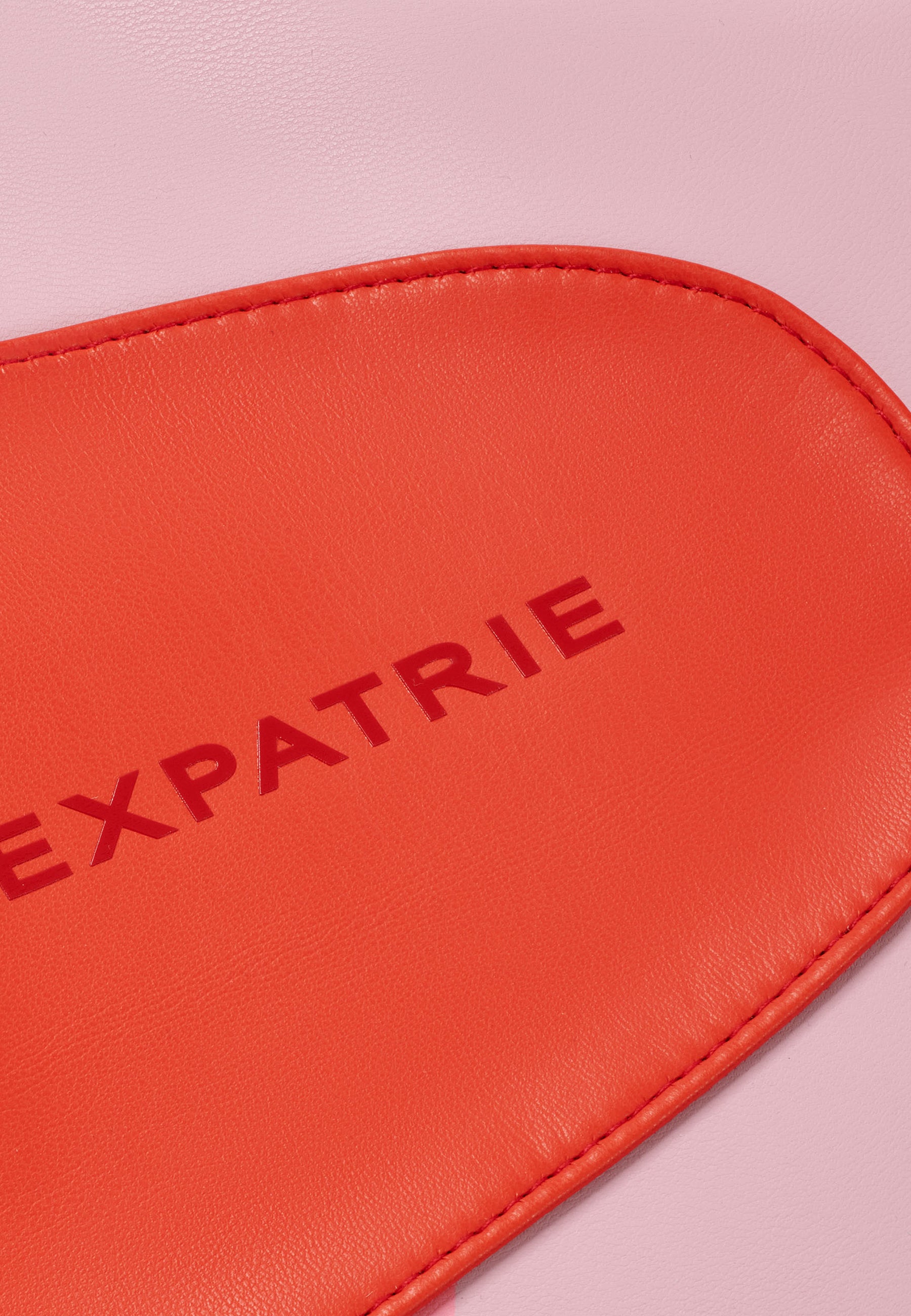 Rotes, kunstledernes LINA Schultertaschen-Detail mit dem Schriftzug 'EXPATRIE'
