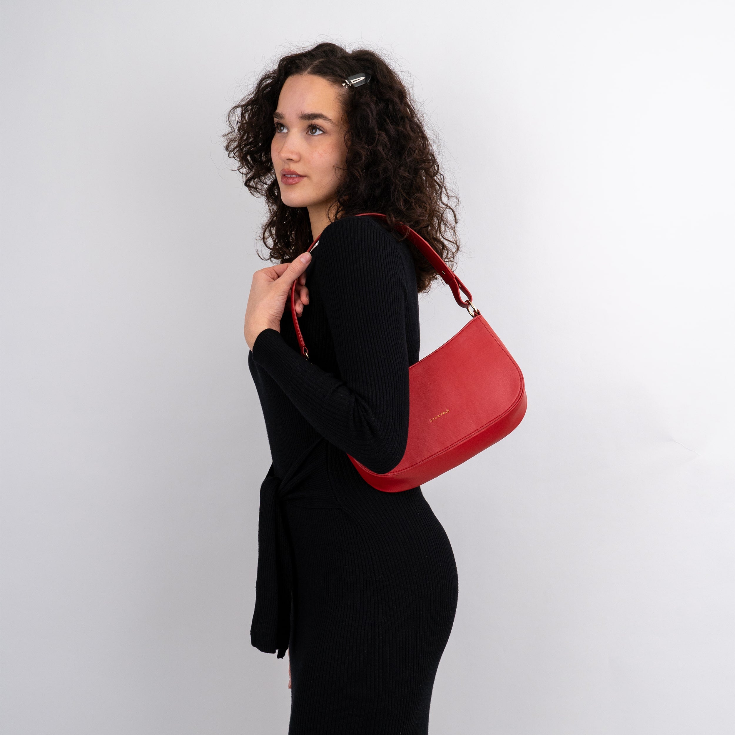Féline rote Handtasche aus Leder, getragen von Frau in schwarzem Kleid