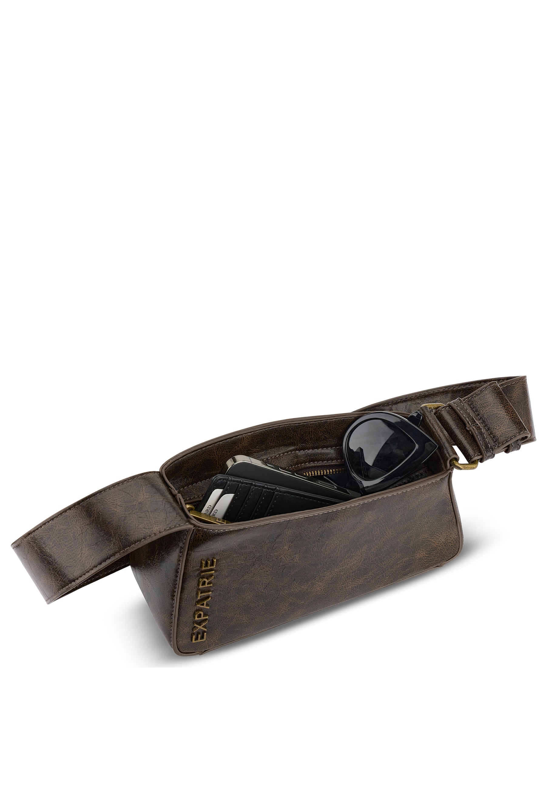 Braune GEORGIA Handtasche von Expatrié mit breitem Riemen, geöffnet mit Sicht auf schwarze Sonnenbrille und Kartenetui