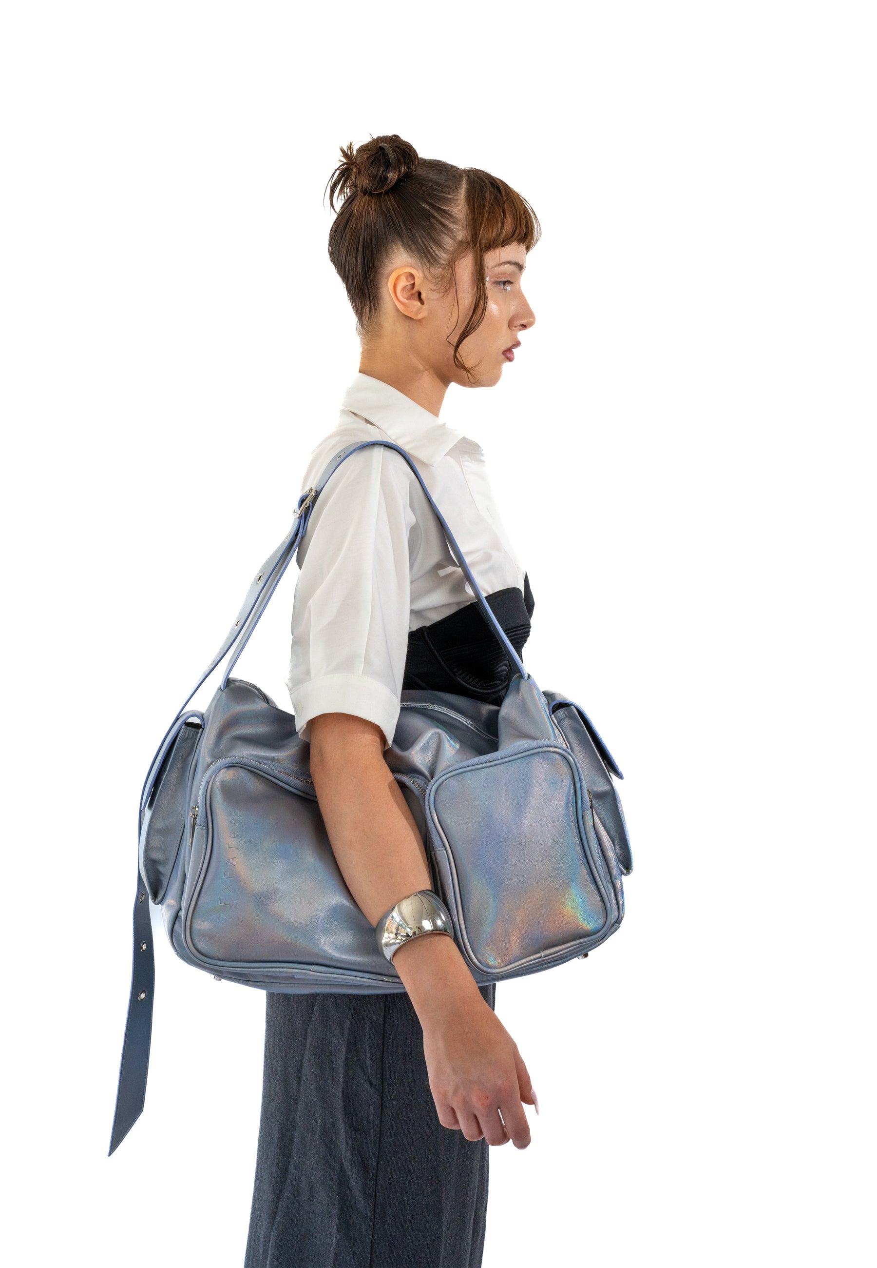 Frau mit lila-metallischer NOVA Weekender Tasche mit mehreren Außentaschen und Schulterriemen