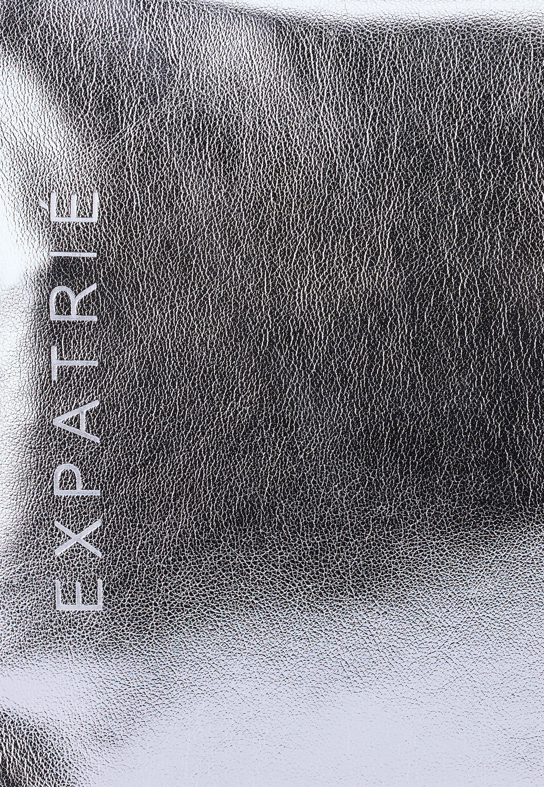 Nahe Ansicht der silber-metallic Oberfläche der NOVA Weekender Tasche von Expatrié mit sichtbarer Markenprägung