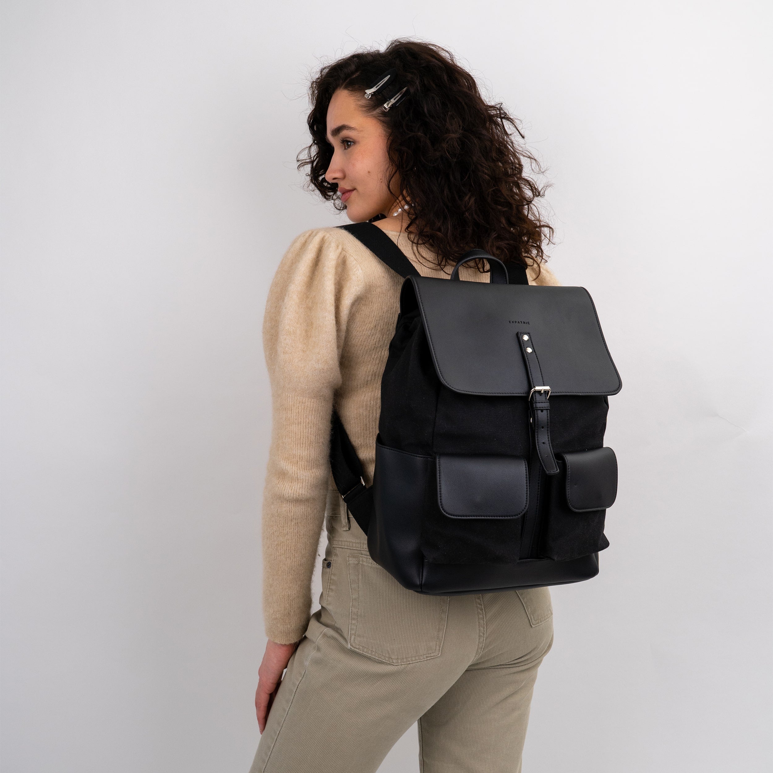 Frau trägt schwarzen Rucksack Laurent aus Canvas und Leder mit Schnalle und Klappentaschen