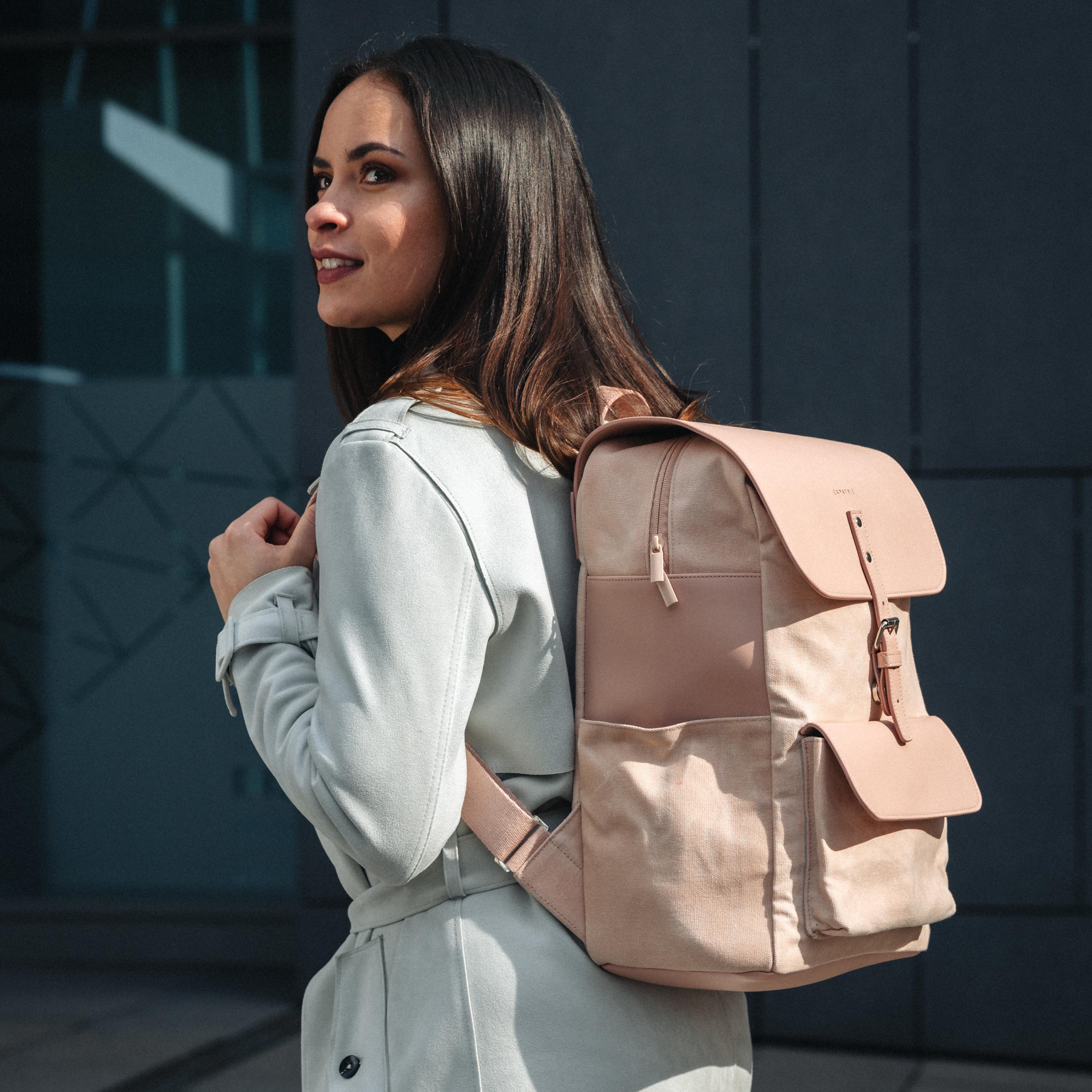 Frau trägt rosa Rucksack Ella aus Canvas und Leder vor dunklem Hintergrund