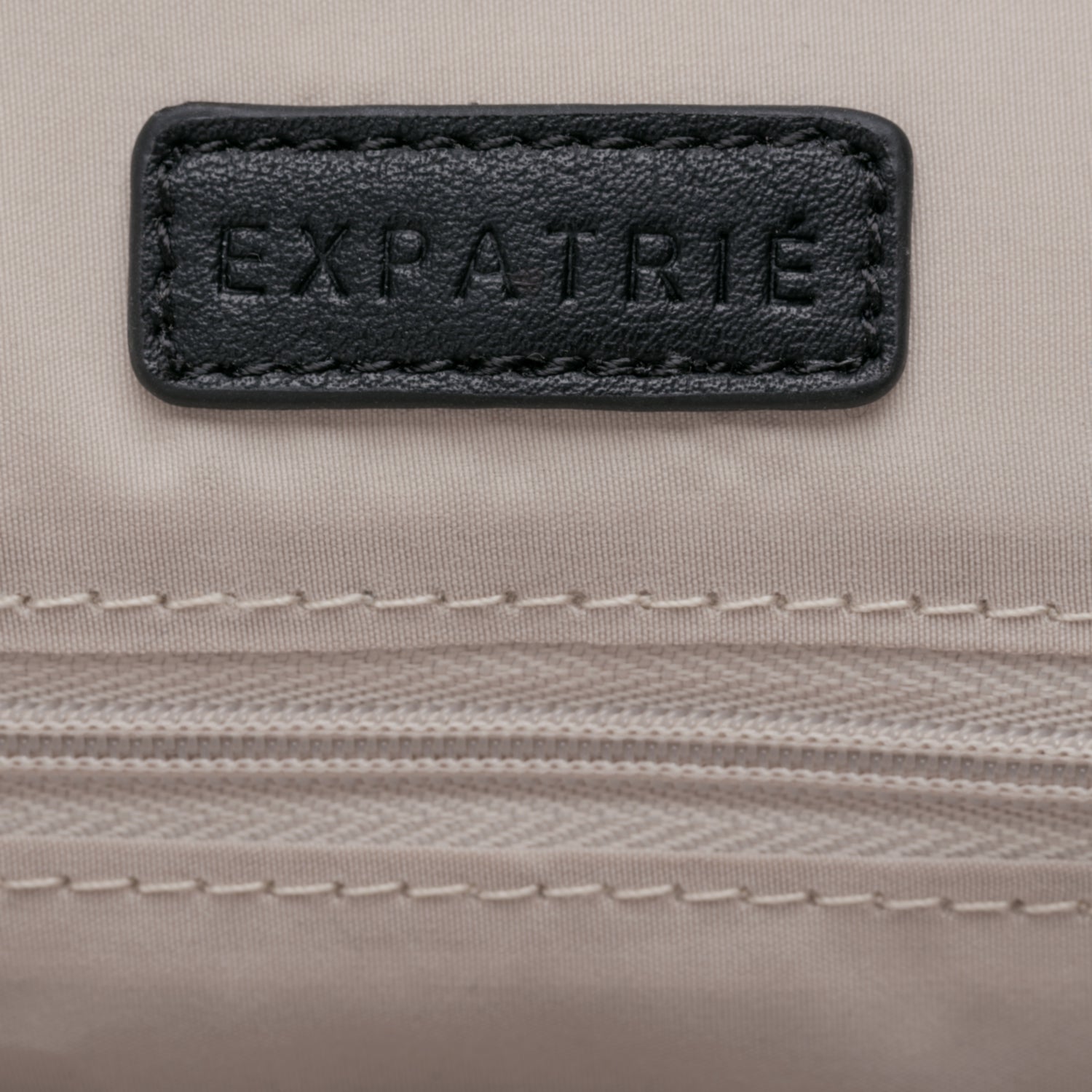 Naht und Reißverschluss mit schwarzem Lederetikett 'EXPATRIE' im Innenfutter der Business Handtasche Odette