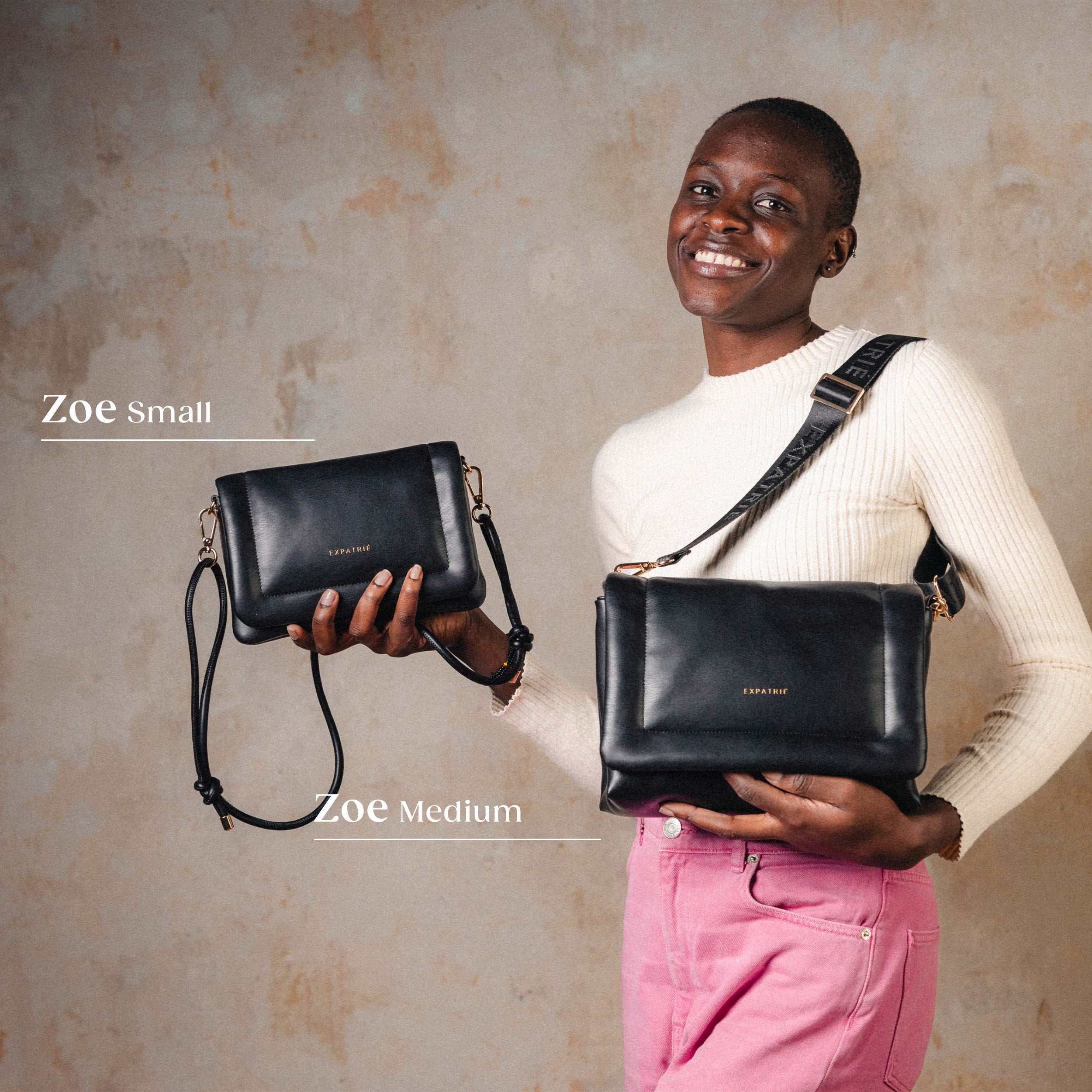 Lächelnde Frau hält schwarze Umhängetaschen 'Zoe Small' und 'Zoe Medium' aus Leder