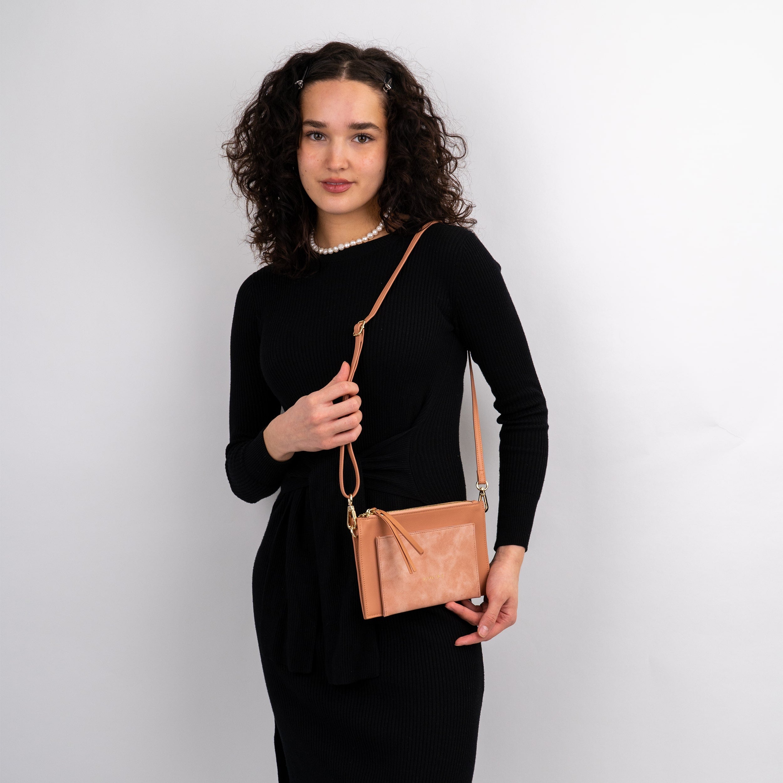 Frau trägt Clutch Isabelle in Nude mit verstellbarem Schulterriemen und Reißverschluss