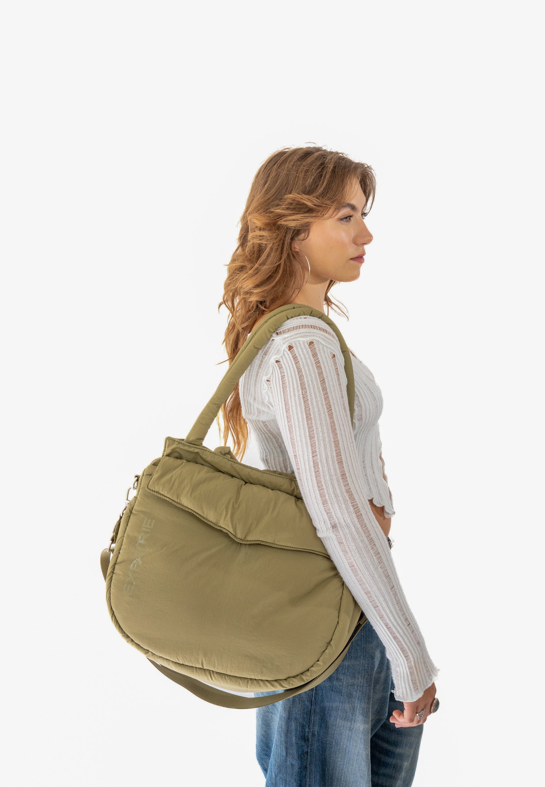 Frau mit langem, gewelltem Haar trägt olivgrüne POPPY Shopper-Tasche über der Schulter